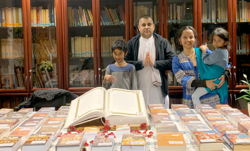 Ananda Jita das en familie met 45 anderstalige exemplaren van de Bhagavad Gita
